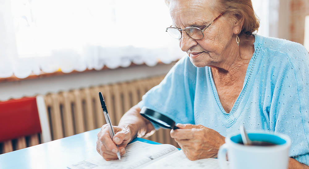 woman using magnifying glass to help read