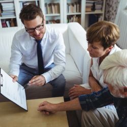 Senior couple speaking with estate planner in living room