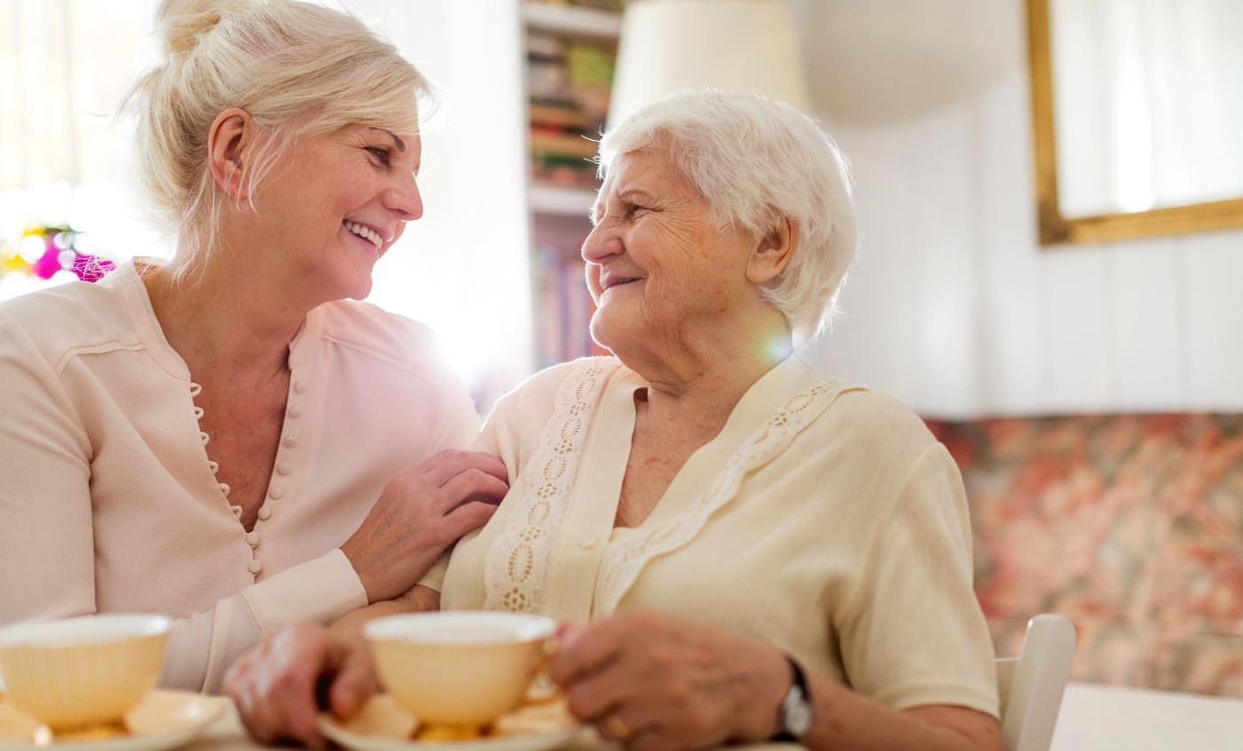 woman has tea with elderly mother